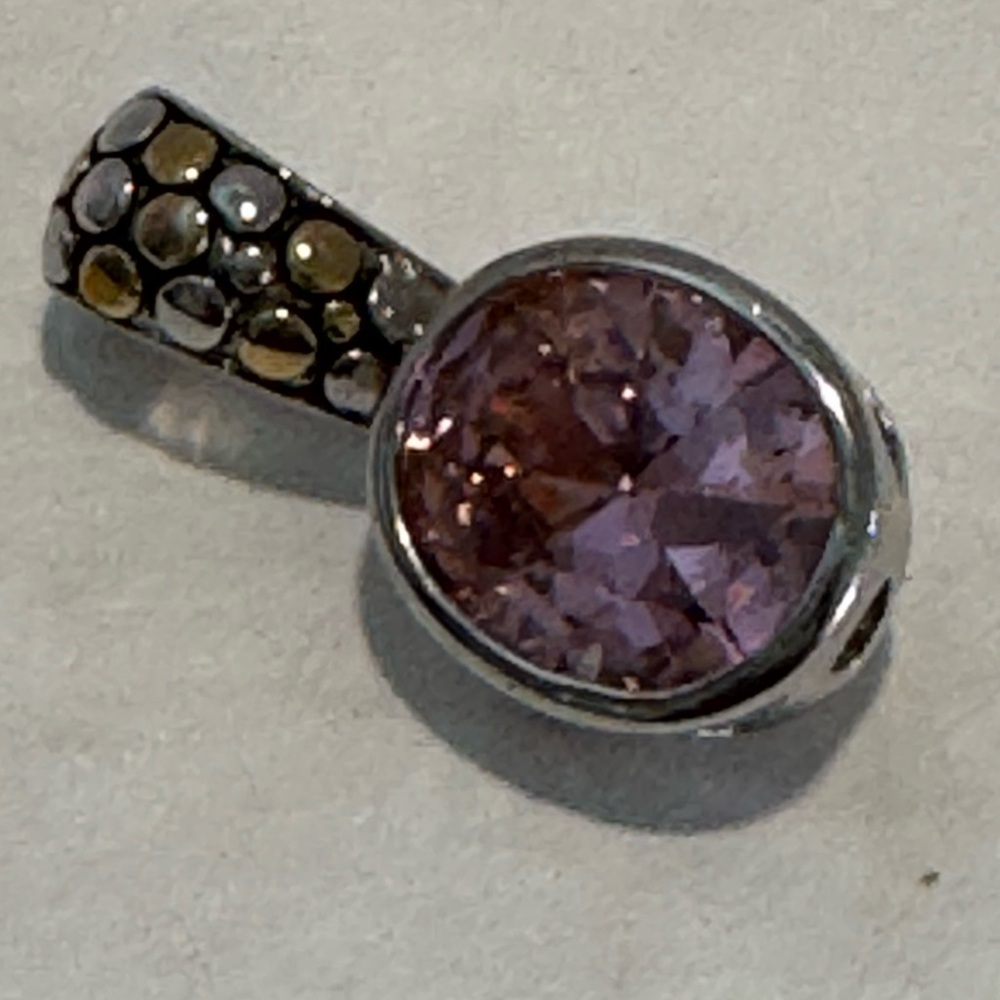 gemstone pendant in a silver-tone setting featuring a textured, multicolored dot